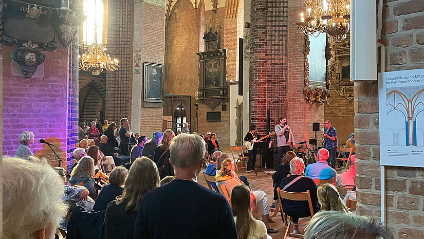 Zuschauer und Zuschauerinnen beim Auftritt einer Band im Schleswiger Dom
