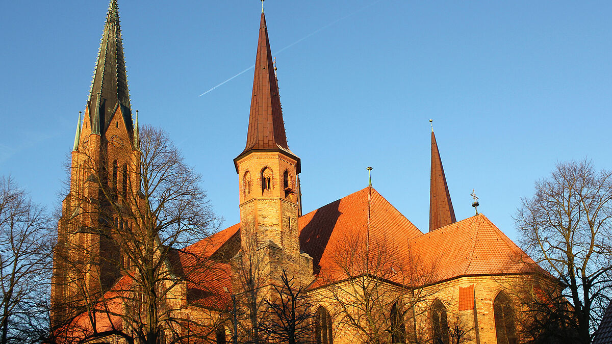 Der Dom im winterlichen Licht: Viele Jahrhunderte lang dominierte das mächtige Hauptschiff des Domes die Altstadt von Schleswig. Vom 12. bis zum 15. Jahrhundert entwickelte sich der Dom von einer romanischen Basilika zu einer gotischen Hallenkirche mit dreischiffigem Chor. Das, was den heutigen Dom prägt, kam in einer letzten, intensiven Bauphase Ende des 19. Jahrhunderts hinzu: der mächtige Westturm, die schlanken Turmaufsätze, die farbigen Maßwerkfenster und die verzierten Giebelaufsätze des Querschiffes.