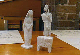 Drei Gipsfiguren zeigen Maria, Joseph und das Jesuskind in der Krippe