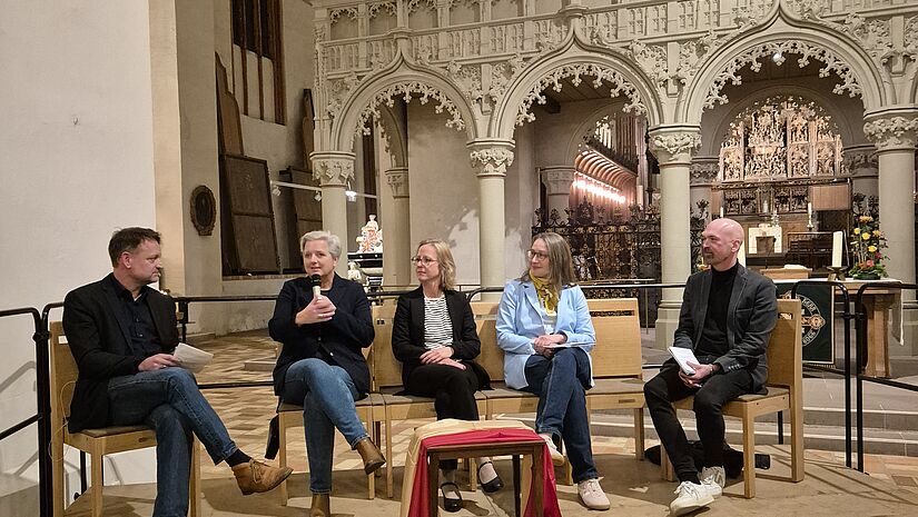 Fünf Menschen haben sich im Dom zur Diskussion versammelt