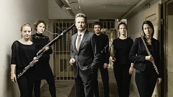 Der Schauspieler Roman Knizka im Kreis von Musikerinnen und Musikern von Opus 45
