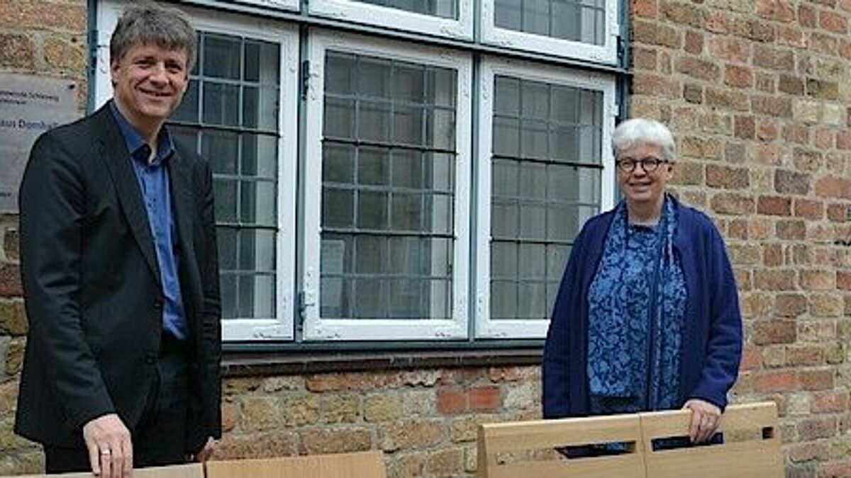 Pastor Michael Dübbers und Pastorin Birgit Johannson zeigen zwei der neuen Stuhlmodelle