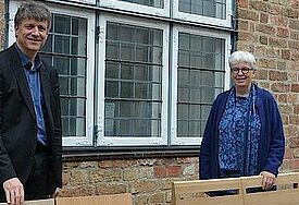 Pastor Michael Dübbers und Pastorin Birgit Johannson zeigen zwei der neuen Stuhlmodelle