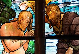 Ein Glasfenster zeigt Johannes den Täufer, der Wasser aus dem Jordan über das Haupt Christi gießt