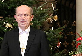 Bischof Magaard vor dem Weihnachtsbaum im Schleswiger Dom